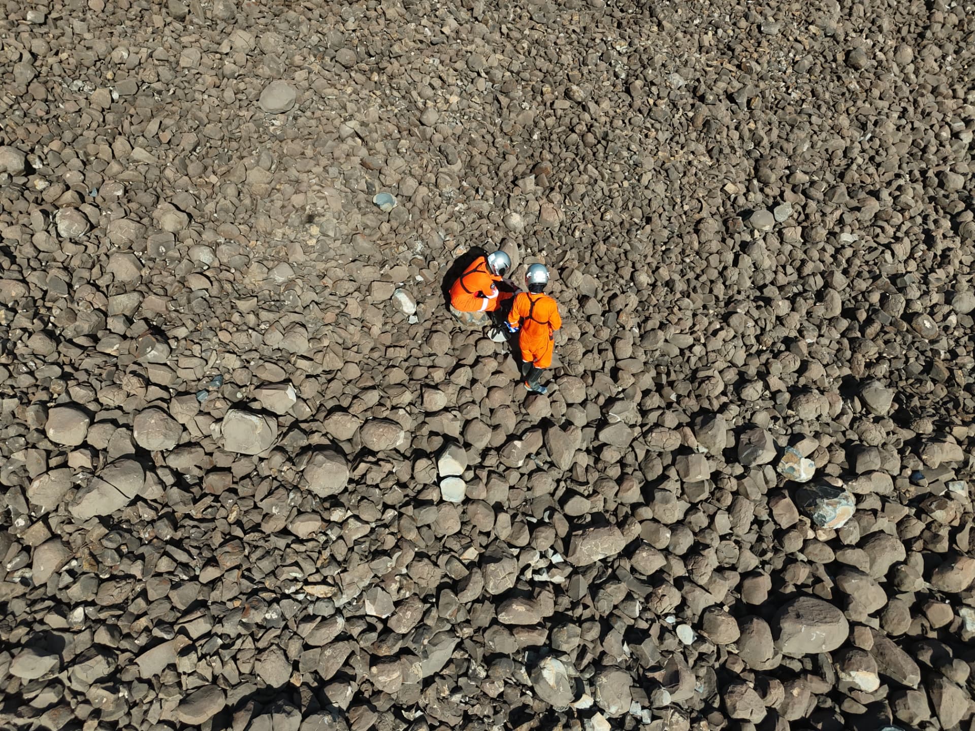 Two analog astronauts traversing the rocky Cabugi terrain
